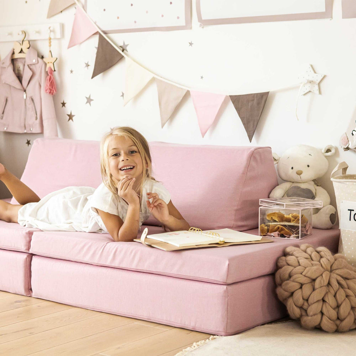 1. Smiling girl on pink play mattress set in a decorated room
