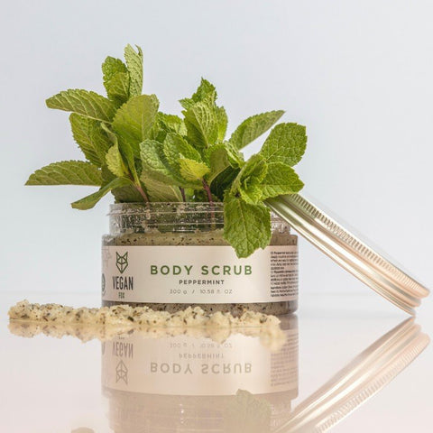4. Vegan Fox Peppermint Body Scrub jar with fresh peppermint leaves, studio setting