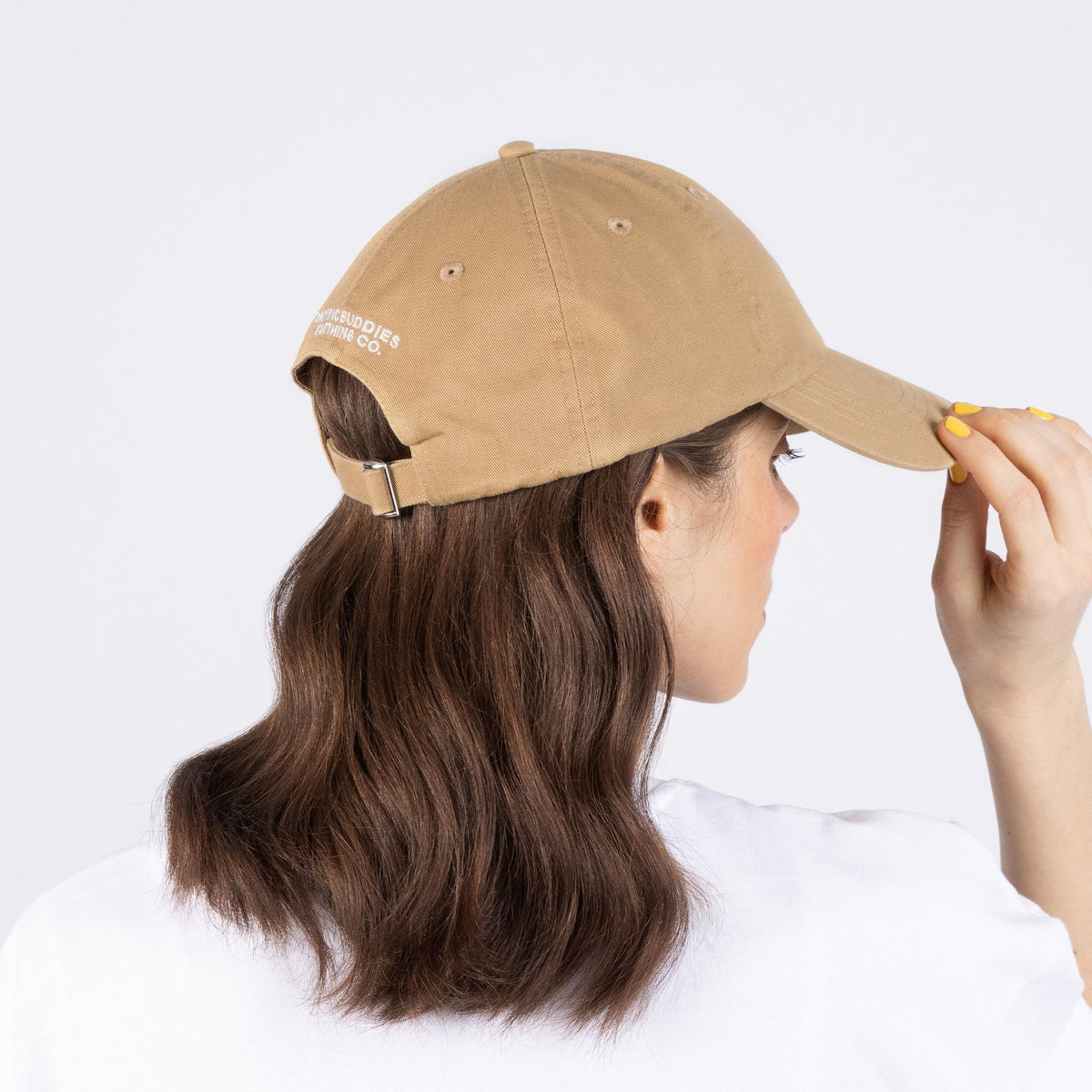 2. Back view of woman wearing Pippi And The Bang Dad Cap in sand color, highlighting adjustable strap