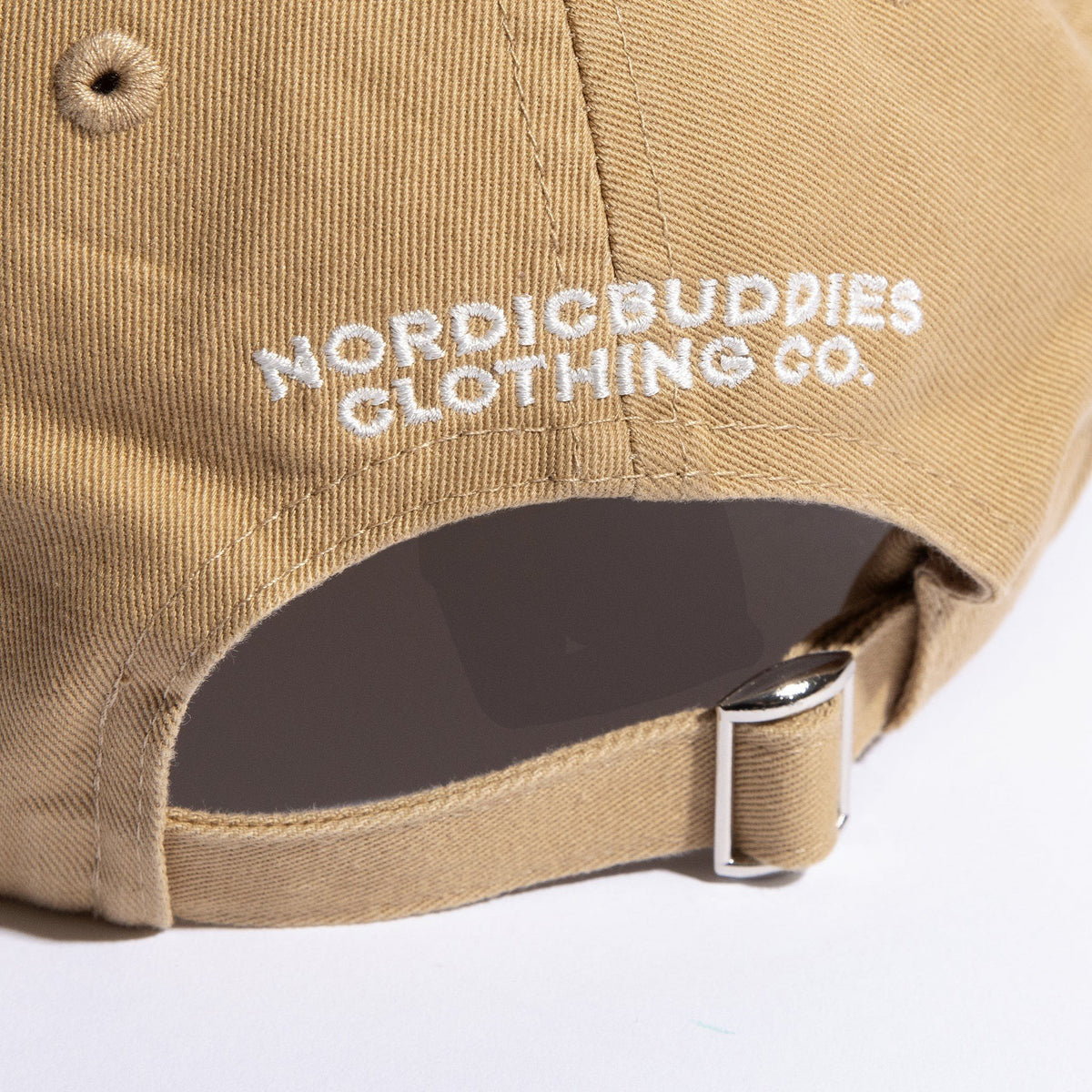 5. Close-up of NordicBuddies Clothing Co. embroidery and adjustable strap on sand dad cap