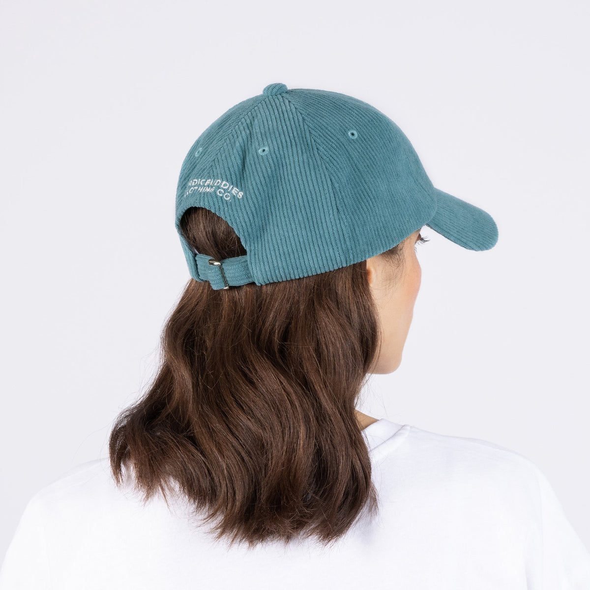 2. Woman wearing Pippi Corduroy Dad Cap in petrol, showing back view with adjustable strap