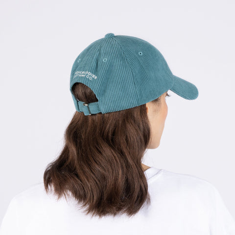 2. Woman wearing Pippi Corduroy Dad Cap in petrol, showing back view with adjustable strap
