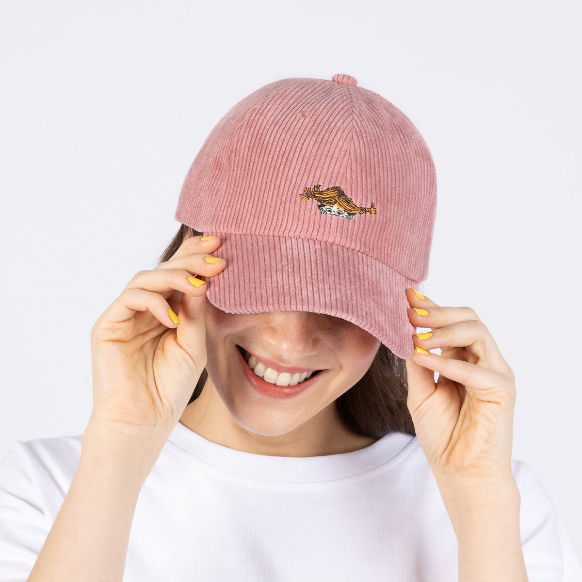 1. Woman wearing pink Pippi Corduroy Dad Cap by Moomin, showing front embroidery, in studio