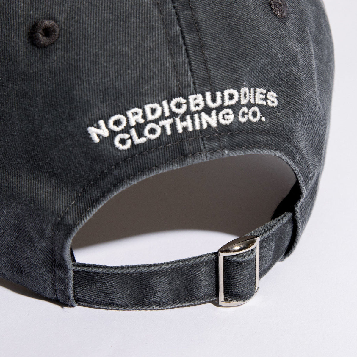 5. Close-up of NordicBuddies logo and adjustable strap on black denim dad cap