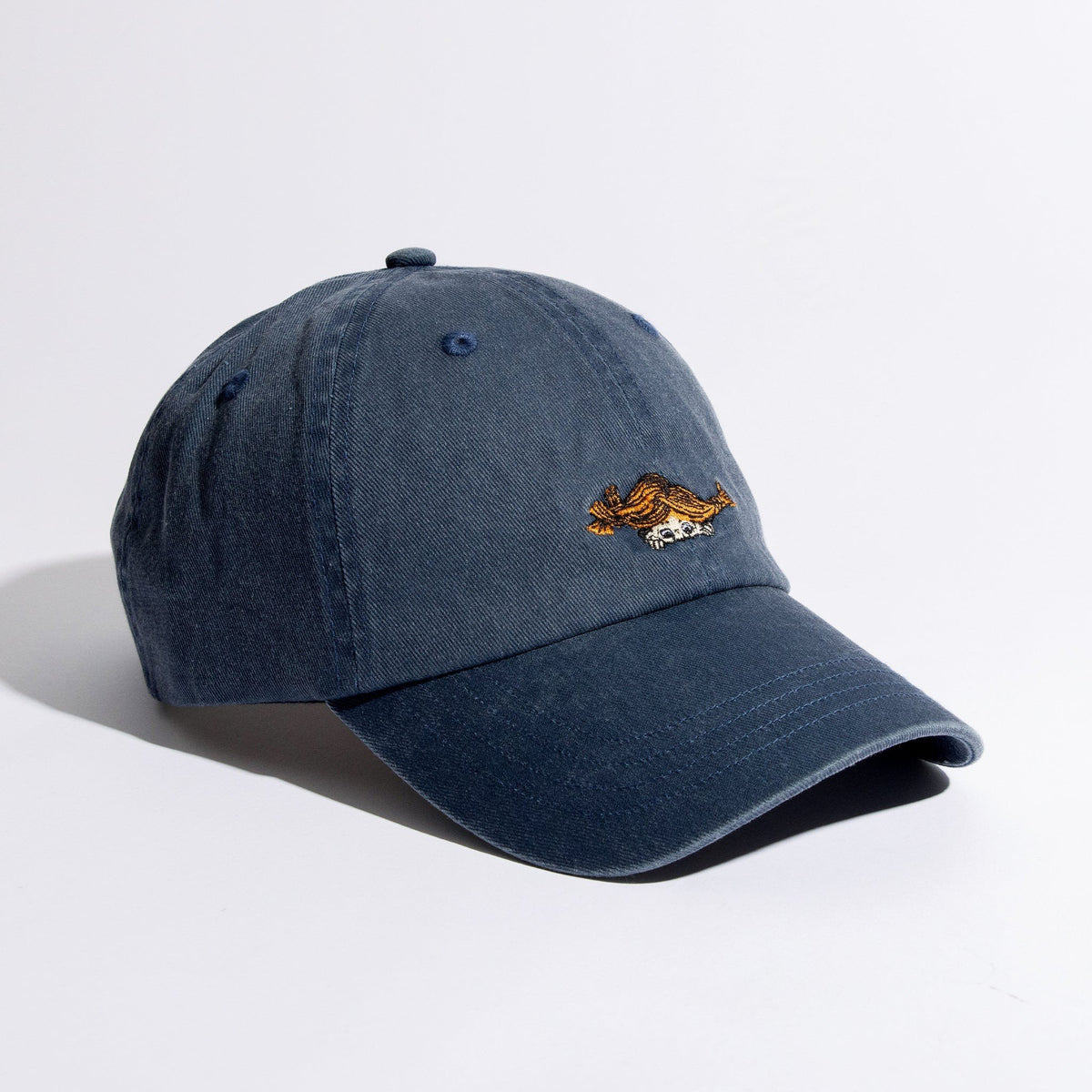 1. Pippi Denim Dad Cap in blue by Moomin, featuring embroidered design, shown in studio setting