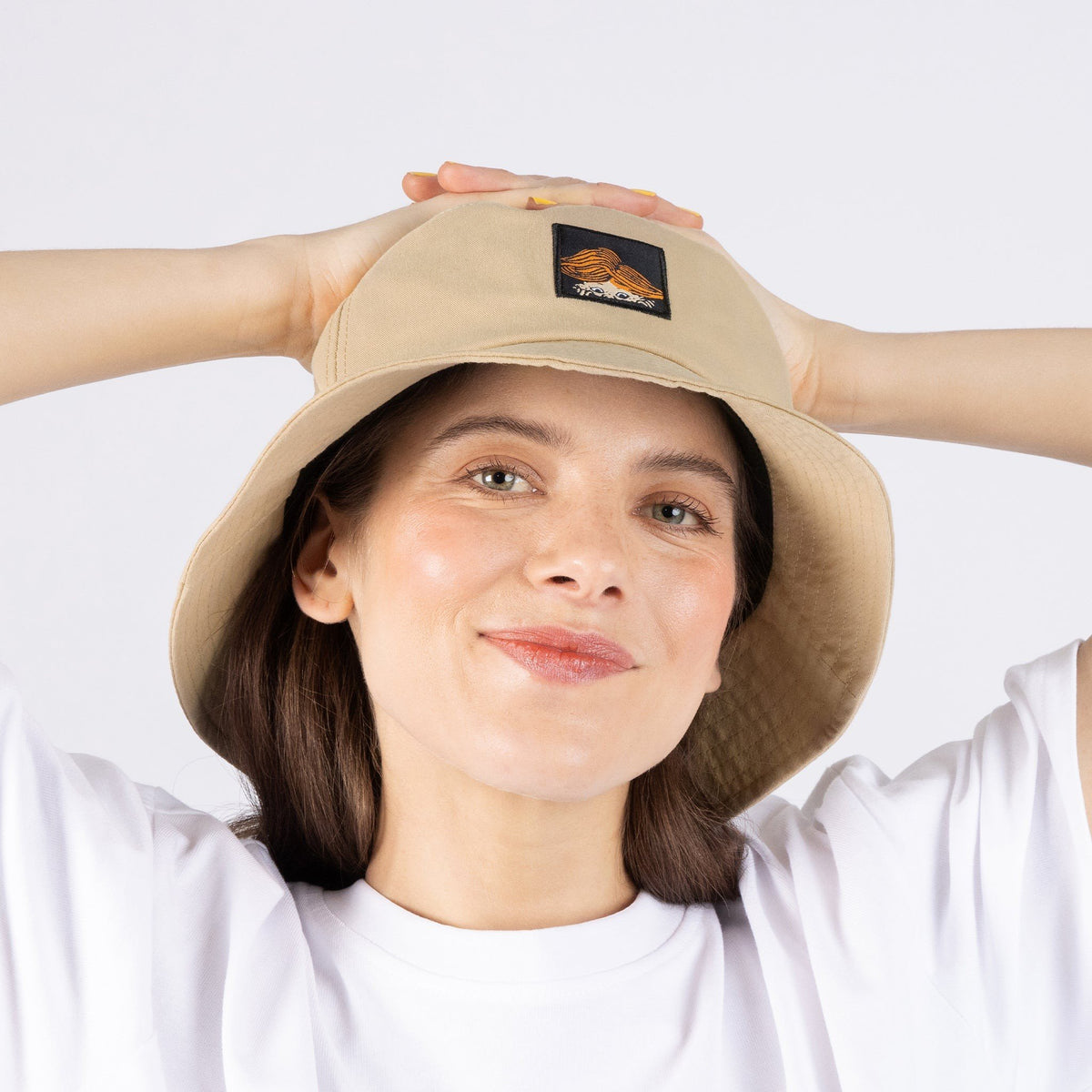 1. Woman wearing Pippi Longstocking beige bucket hat by NordicBuddies, showcasing front design