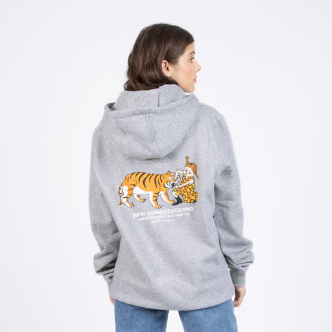 1. Woman wearing Pippi Longstocking unisex heavy hoodie in grey, showing back design with tiger and Pippi illustration