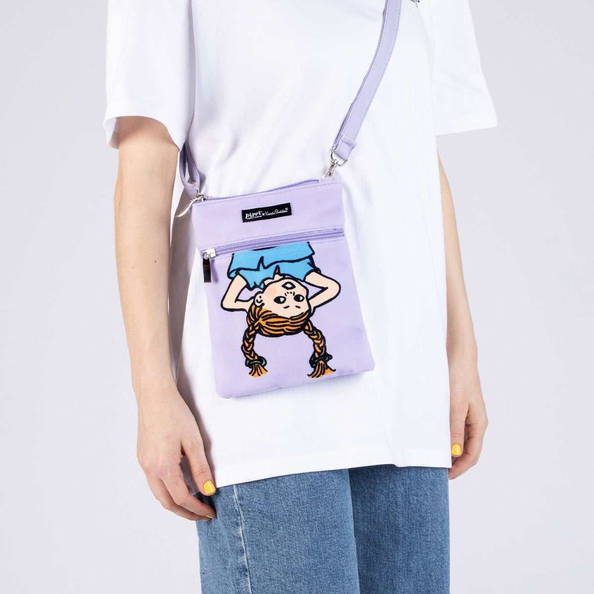 1. Women's Pippi Passport Bag in lilac by Moomin, worn crossbody with casual outfit
