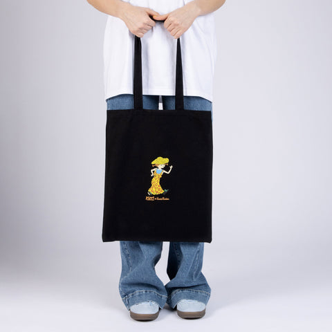 2. Black Pippi Tote Bag with Pippi Longstocking design, held by model, highlighting playful print and dimensions