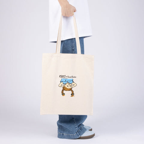 1. Pippi Tote Bag - Upside Down by Moomin, held by a person, showcasing Pippi Longstocking design in natural white heavy cotton