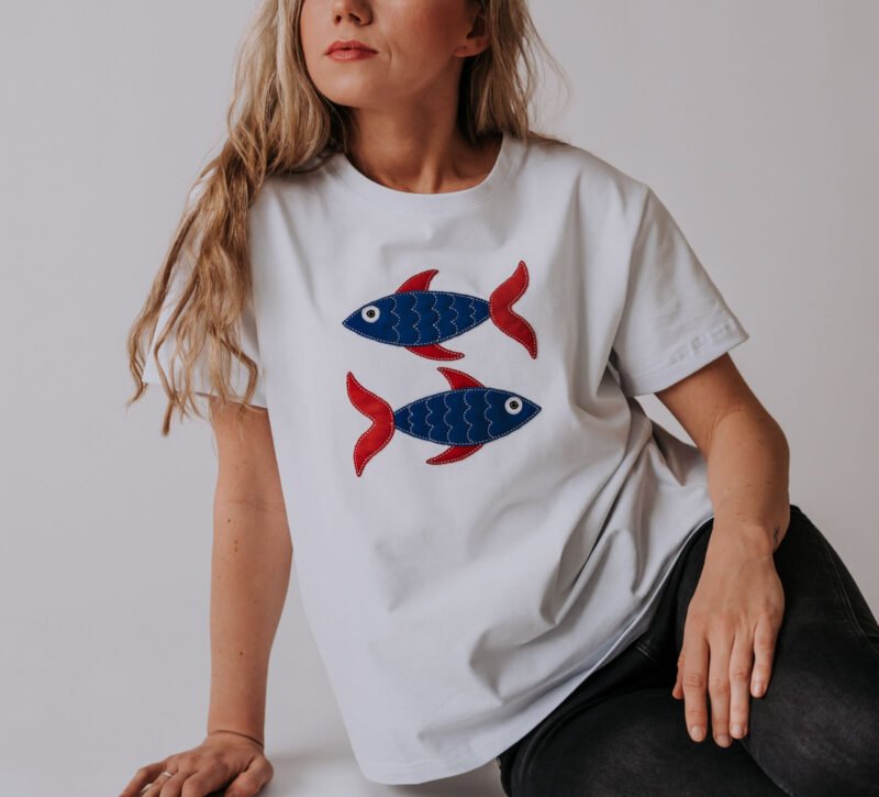 2. Women's Pisces T-shirt in white with fish motif, styled casually by model