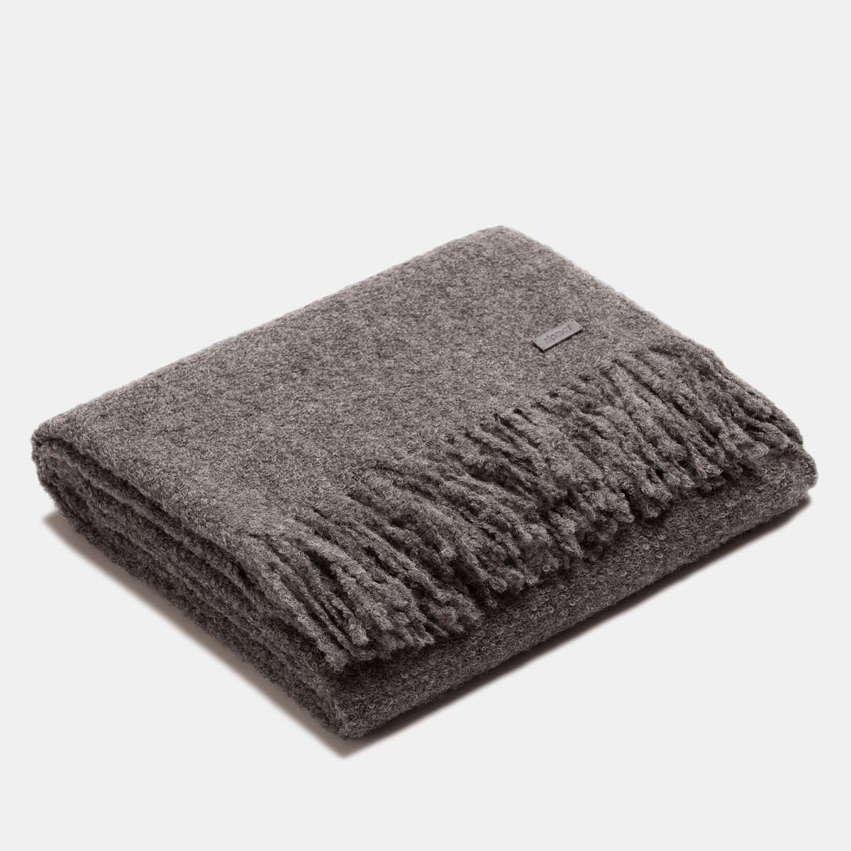 6. Folded dark grey superfine alpaca wool boucle throw with fringe, displaying luxurious texture and style
