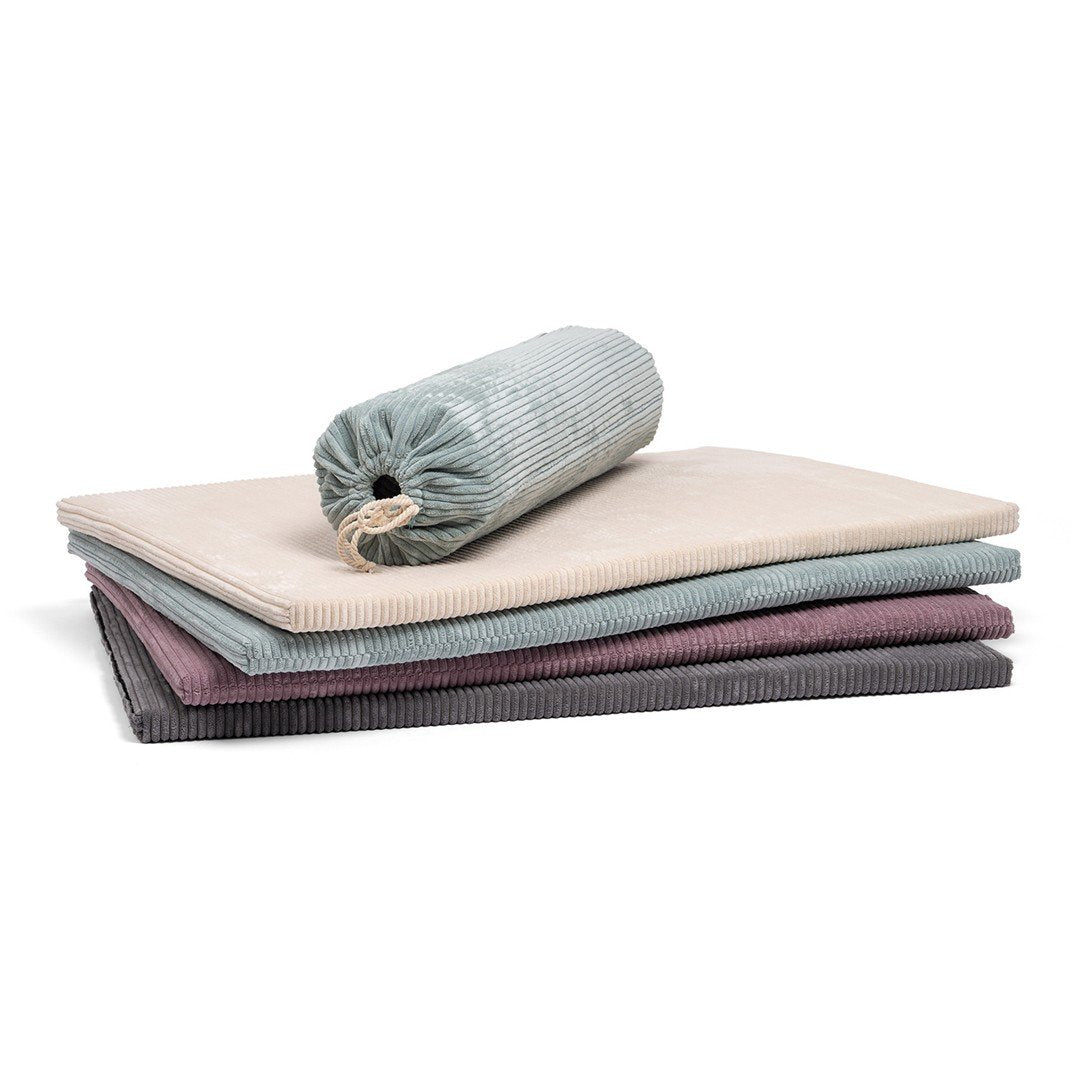 1. Stack of Luula play mats in mint green, cannon pink, milky white, and shadow gray with a rolled mat on top