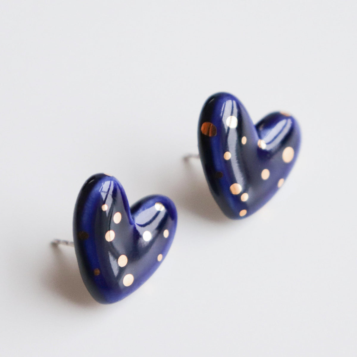 5. Studio image of Rozenthal blue porcelain heart studs with gold accents, showing sterling silver posts