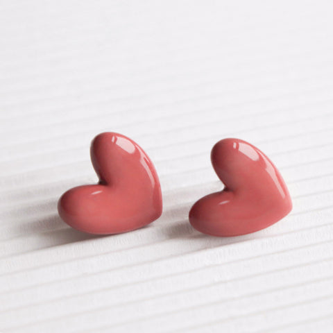 4. Pair of Rozenthal pink porcelain heart studs displayed on a textured surface