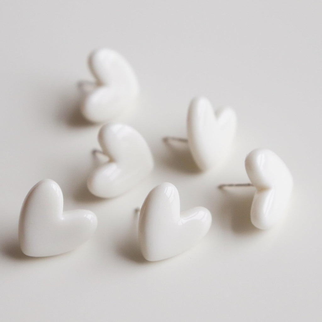 8. Flat lay of Rozenthal Porcelain Heart Studs in white, emphasizing minimalist design