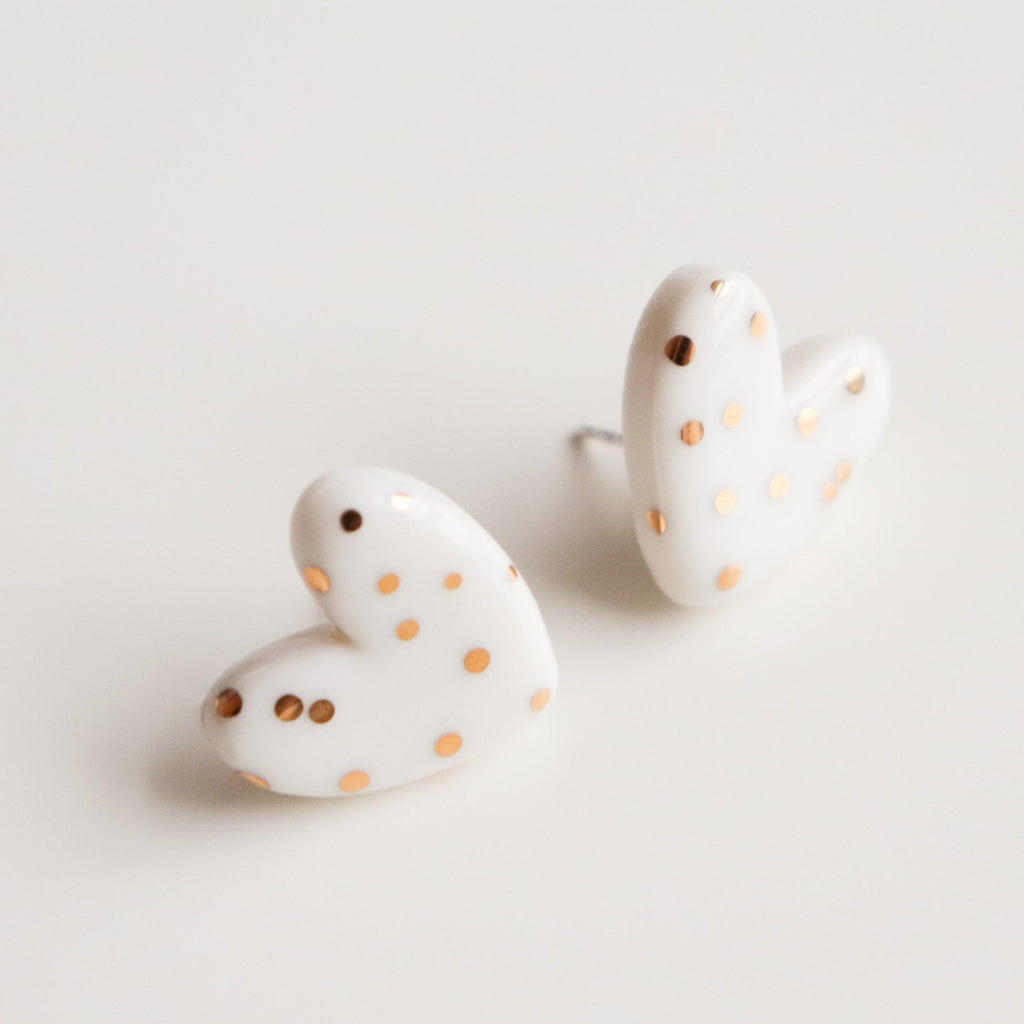 3. Studio shot of Rozenthal dotted porcelain heart studs with 24k gold accents on white background
