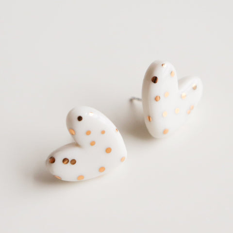 3. Studio shot of Rozenthal dotted porcelain heart studs with 24k gold accents on white background