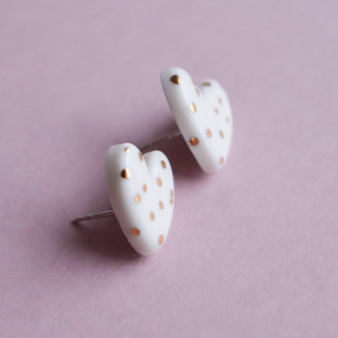 5. Close-up of Rozenthal dotted porcelain heart studs with 24k gold accents, shown on pink background