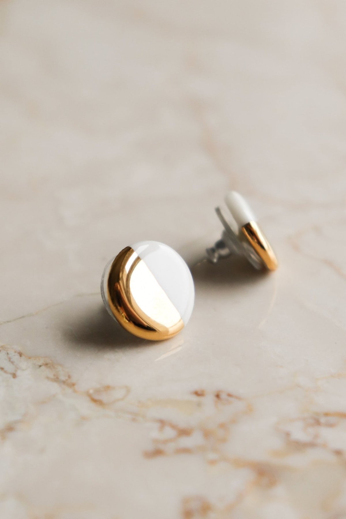 4. Close-up of Rozenthal porcelain round stud earrings in white and gold, highlighting hand-painted 24k gold