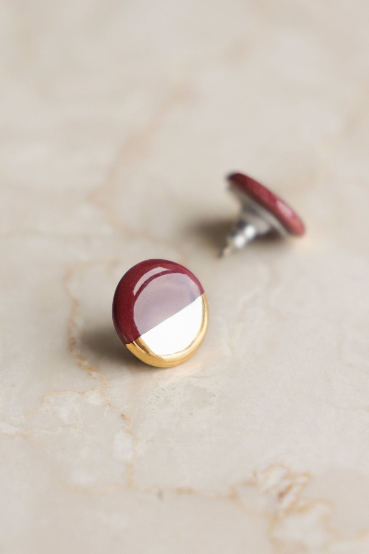 3. Studio shot of Rozenthal Porcelain Round Stud Earrings in Burgundy and Gold, showcasing hand-painted 24k gold detail