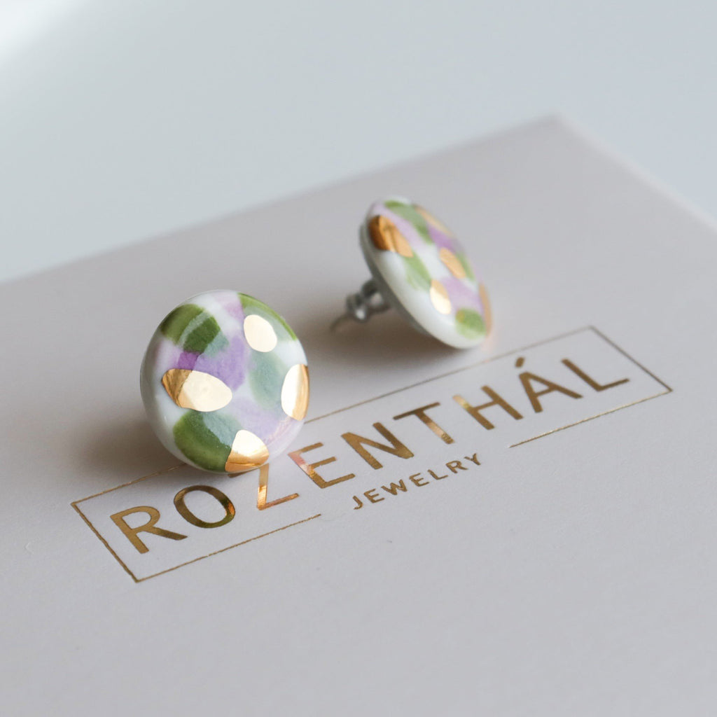 4. Rozenthal Porcelain Tache Studs in green and violet on branded packaging, highlighting 24k gold accents