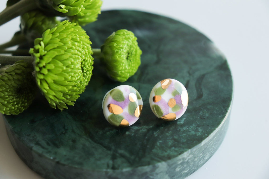 7. Rozenthal Porcelain Tache Studs in green and violet on marble surface, showcasing unique color splashes
