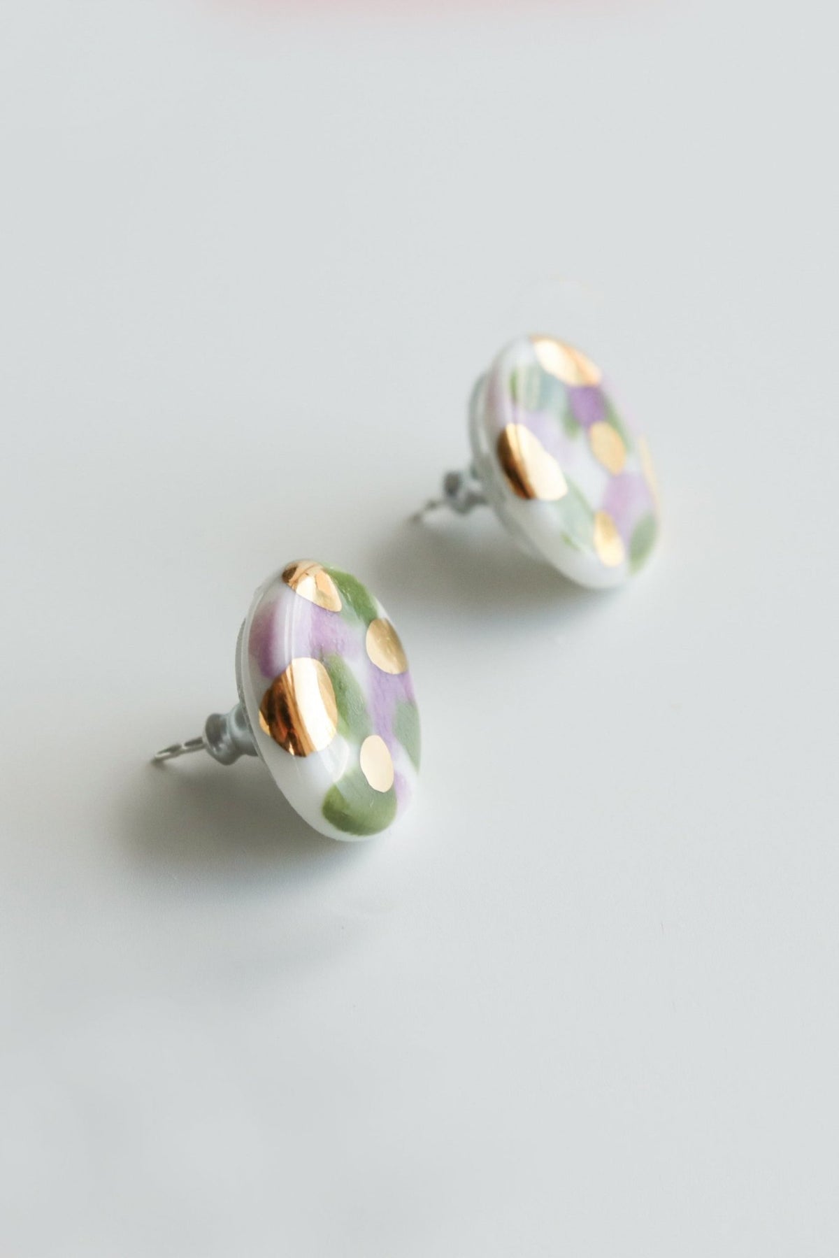 2. Close-up of Rozenthal Porcelain Tache Studs in green and violet with 24k gold detailing on sterling silver
