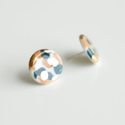 2. Studio shot of Rozenthal Porcelain Tache Studs in green and orange, highlighting hand-painted porcelain with 24k gold