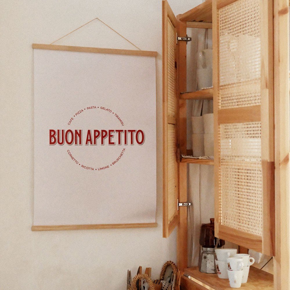 2. Buon Appetito poster with red Italian typography hanging in a cozy kitchen setting with wooden cabinets and cups, enhancing a warm, rustic atmosphere