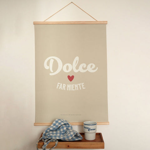 1. Minimalist poster with 'Dolce far Niente' text in white and red heart on beige background, hanging above a wooden shelf with a blue checkered cloth and a mug