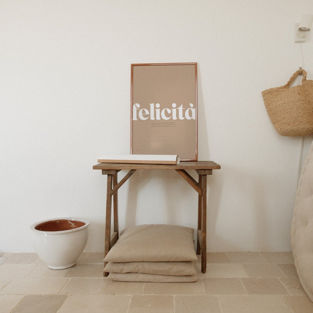 2. Terra Mamma Felicita poster with Italian typography on wooden table with cushions and ceramic pot
