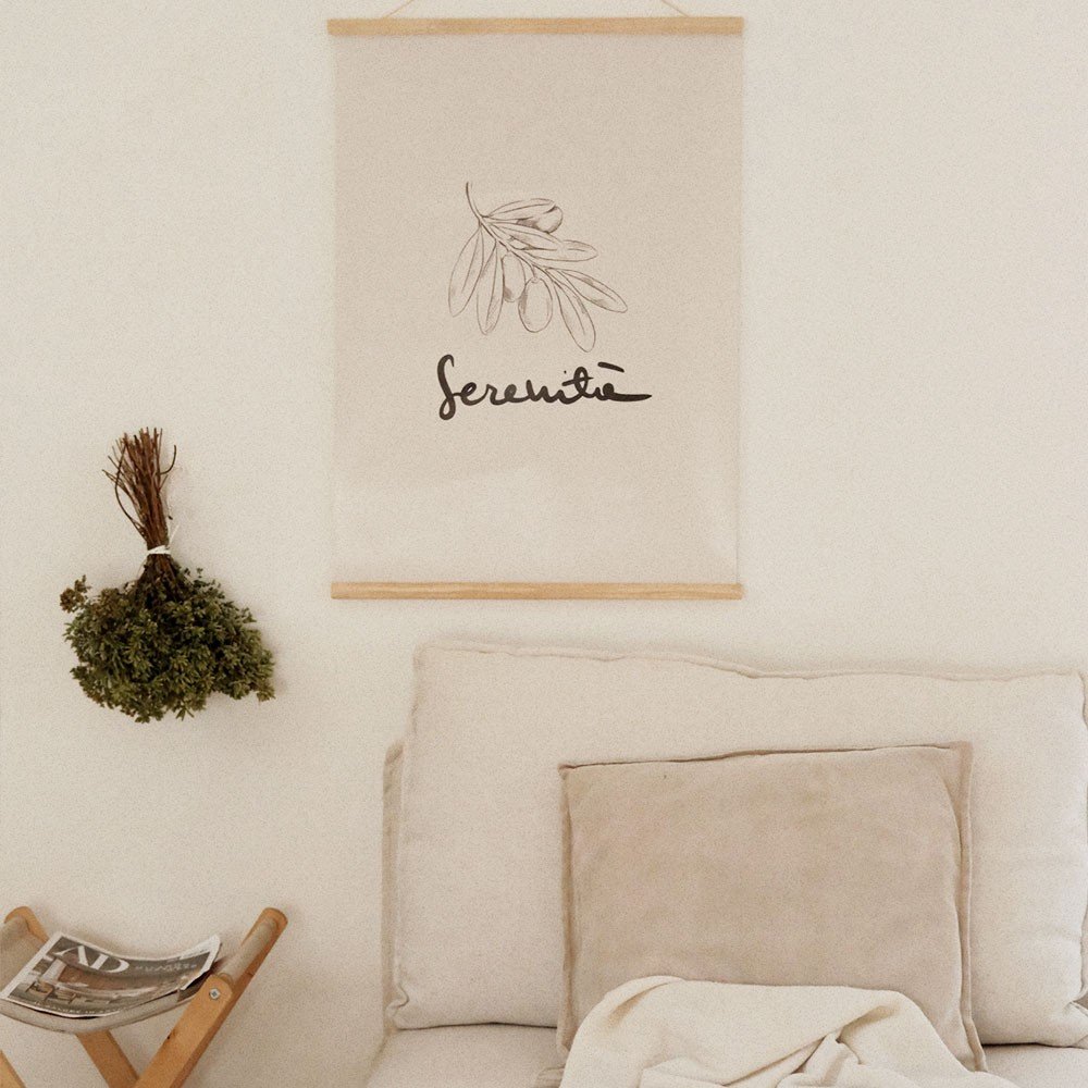 4. Terra Mamma Serenita poster with elegant Italian typography hanging above a beige sofa with cushions