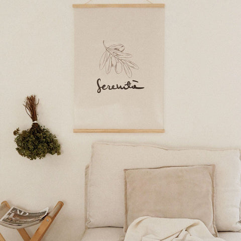 4. Terra Mamma Serenita poster with elegant Italian typography hanging above a beige sofa with cushions