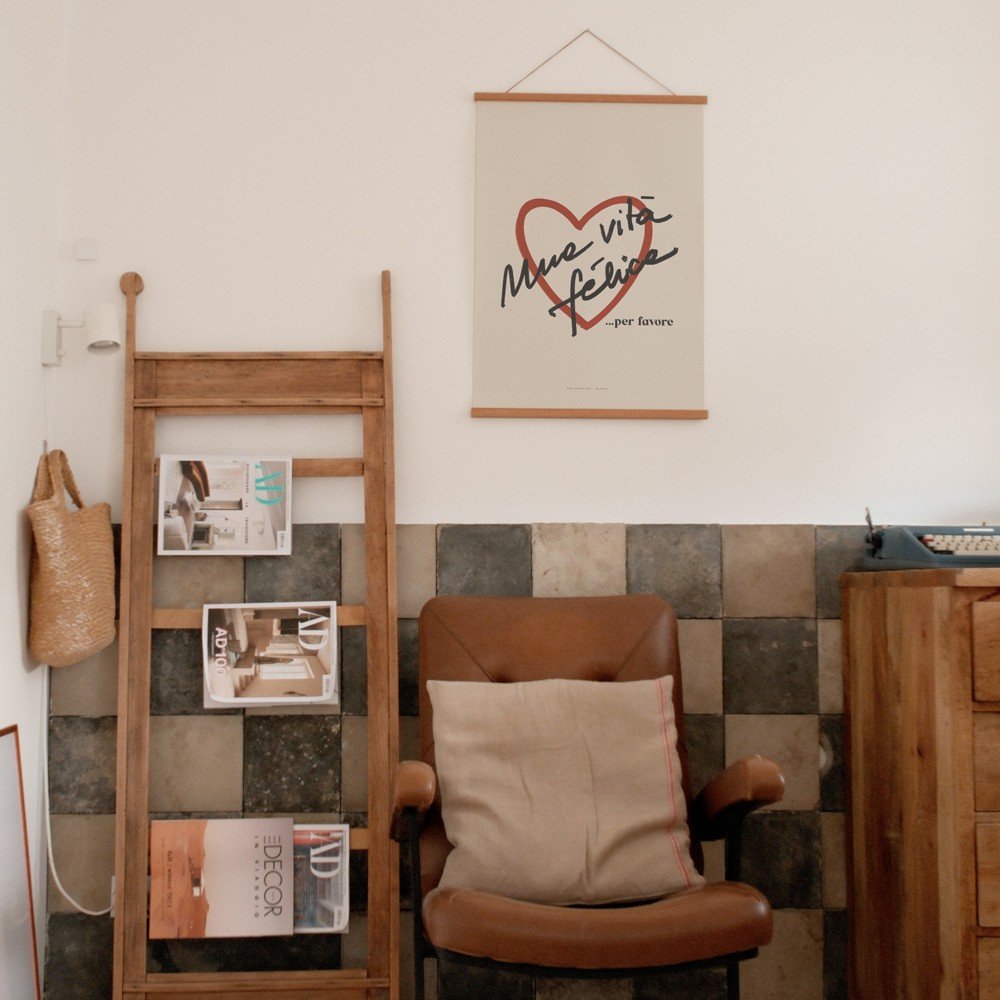 3. Terra Mamma Vita Felice poster hanging above a leather chair in a cozy room with wooden decor