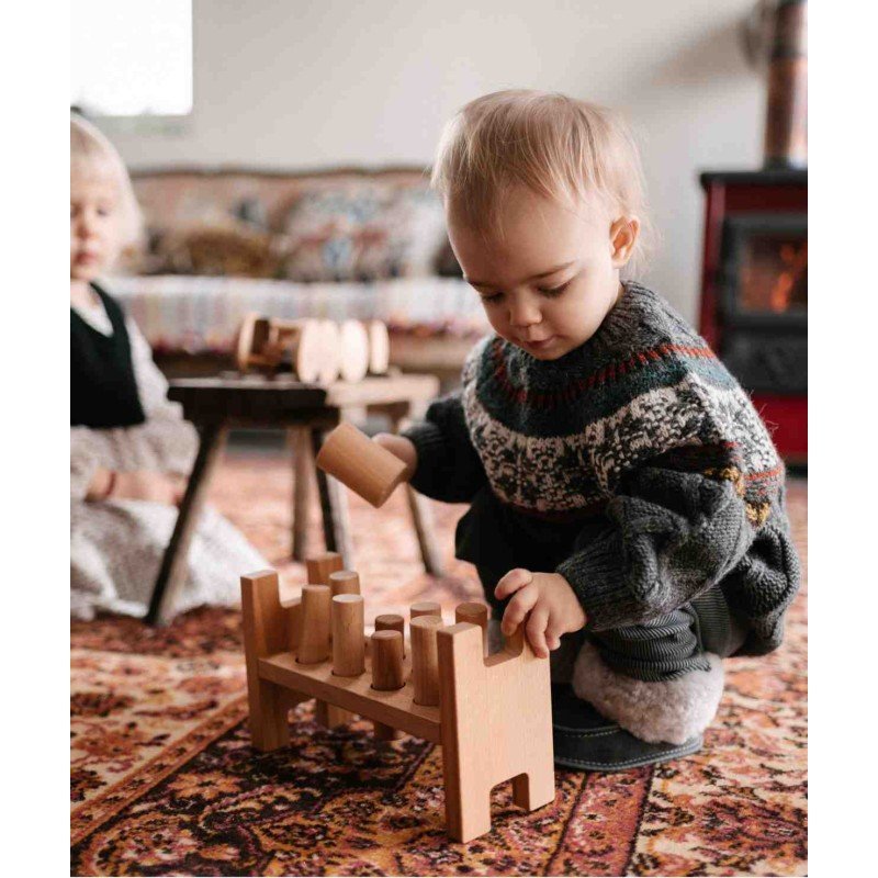 1. Two children playing with Wooden Story Pounding Bench on a patterned rug in a cozy room