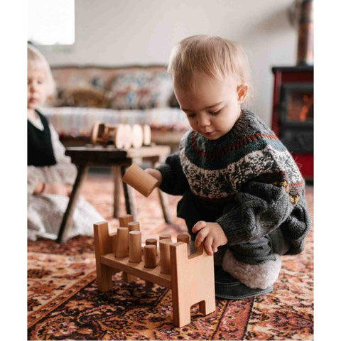 1. Two children playing with Wooden Story Pounding Bench on a patterned rug in a cozy room