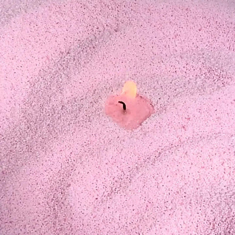3. Close-up of lit wick in baby pink powdered candle sand