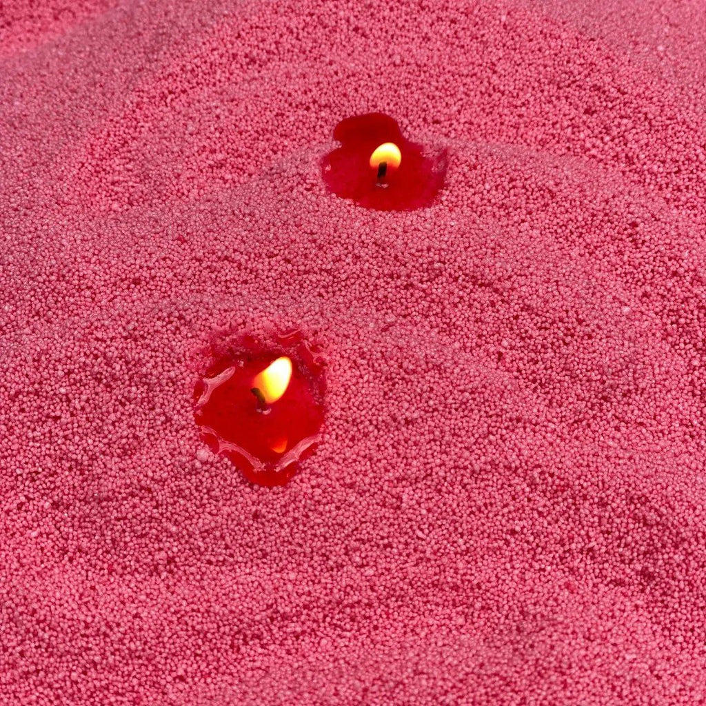 3. Close-up of Blush Vintage candle sand with two lit wicks, showing texture and flame
