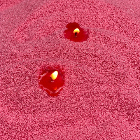 3. Close-up of Blush Vintage candle sand with two lit wicks, showing texture and flame