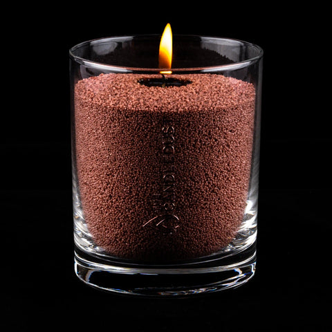 5. Pecan powdered candle in clear glass container with lit wick on black background