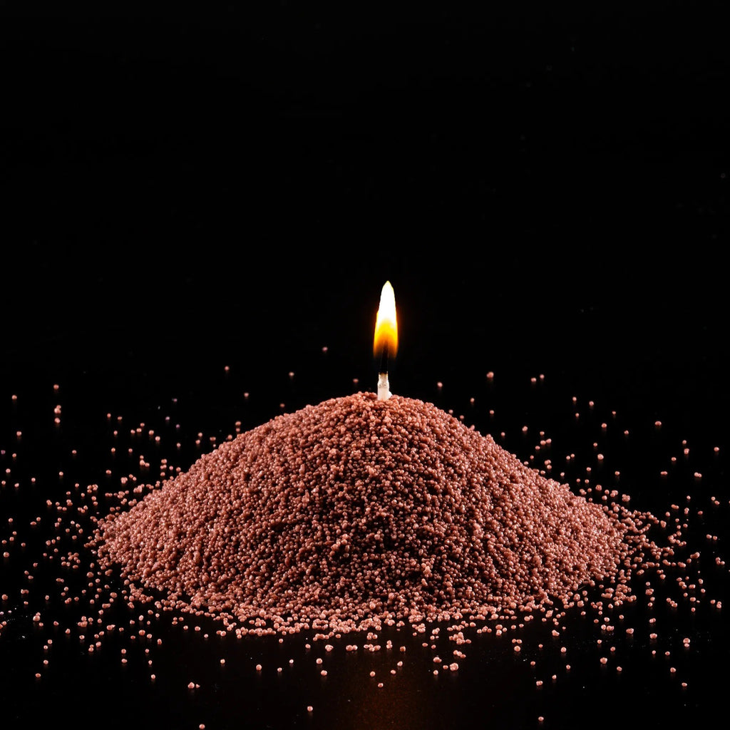 3. Close-up of lit pecan powdered candle with flame on black background