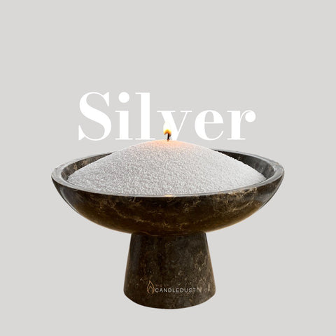 2. Candledust silver candle sand in a dark stone bowl with a lit wick, text 'Silver' above, on a light background