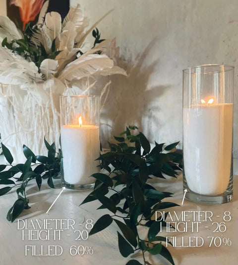 1. Two glass vases with white candle sand and lit wicks, surrounded by greenery and decorative feathers, with size details