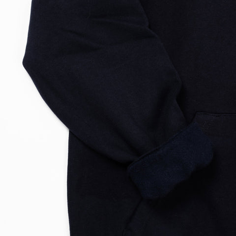 3. Close-up of navy hoodie sleeve and pocket detail highlighting fabric texture