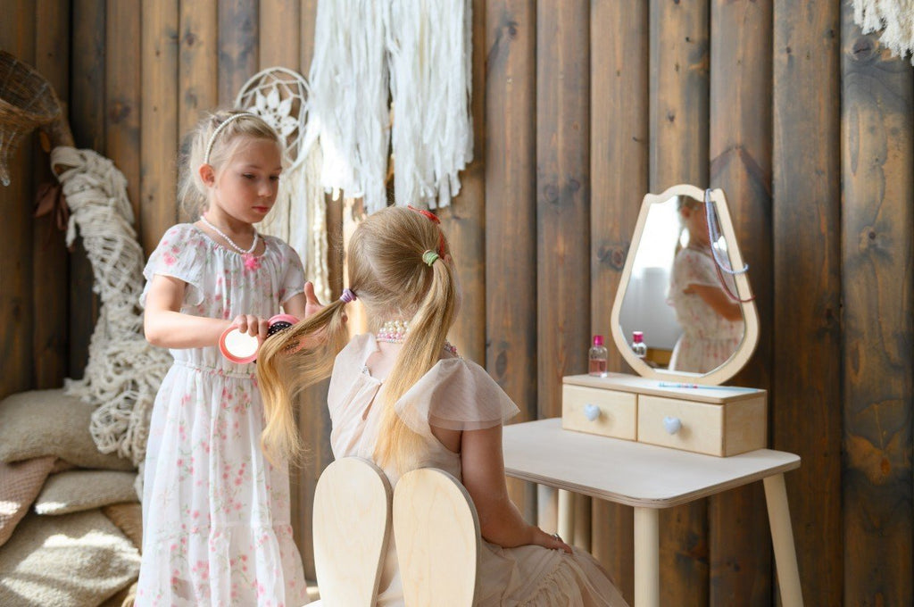 1. Two young girls playing with a white beauty table set in a cozy room, enhancing imaginative play.