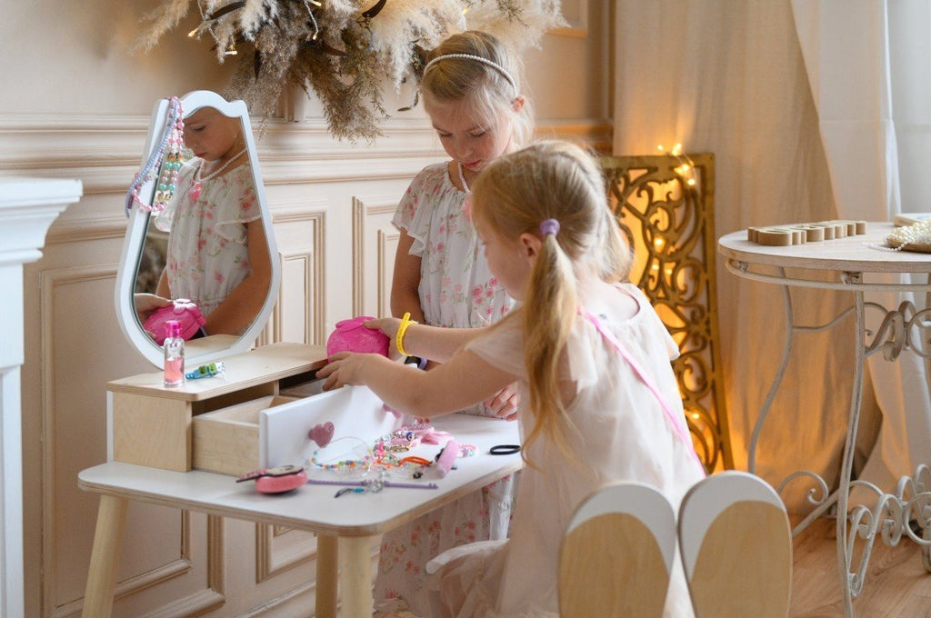 1. Two girls engaging in imaginative play with a white beauty table set in a stylish room.