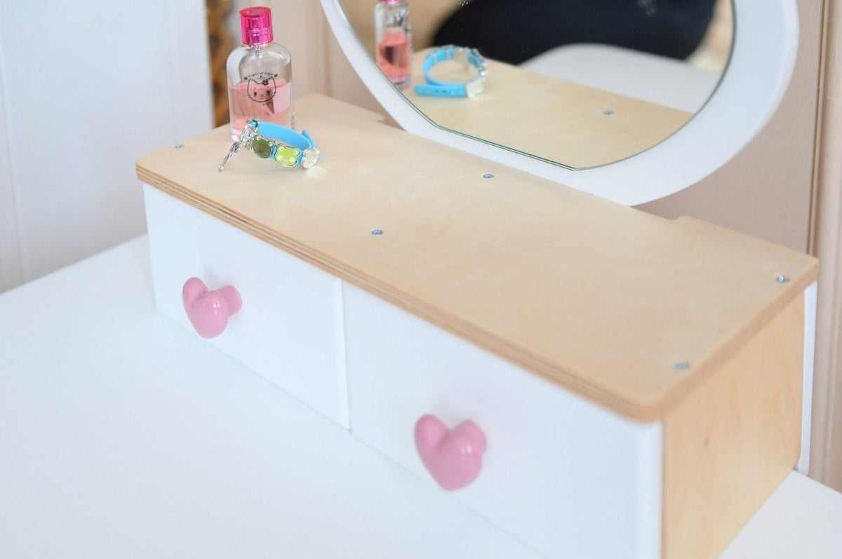 3. Close-up of wooden beauty table with heart-shaped drawer knobs, featuring pretend makeup and accessories.