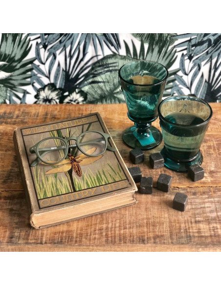 9. Two blue La Rochère Bee Glasses on a wooden table with a book and decorative items
