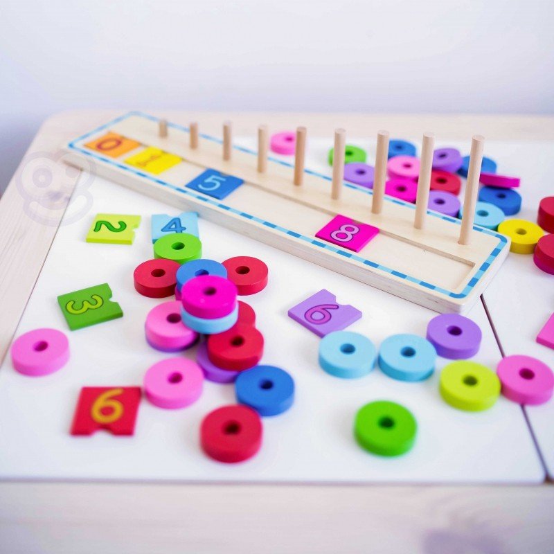 7. Colorful wooden counting puzzle with scattered rings on a white table